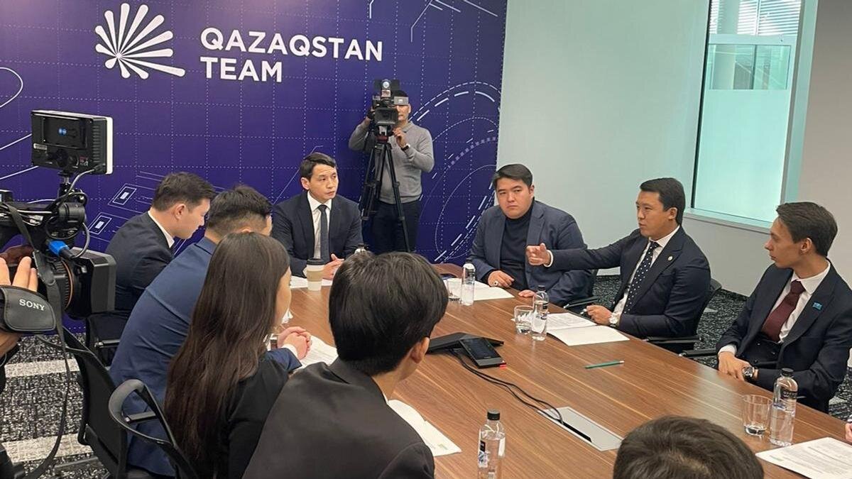    Члены молодежного объединения сидят на конференции:Qazaqstan Teaм