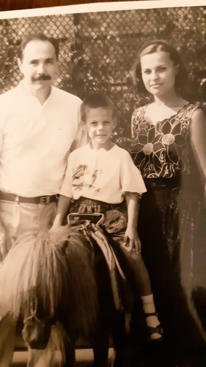 счастливый Тимур с родителями на пони для привлечения внимания