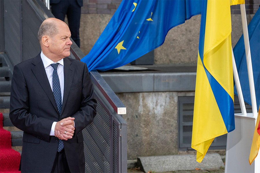 Канцлер Германии Олаф Шольц на фоне флагов Евросоюза и Украины - Фото: Christophe Gateau/dpa/picture-alliance/TASS