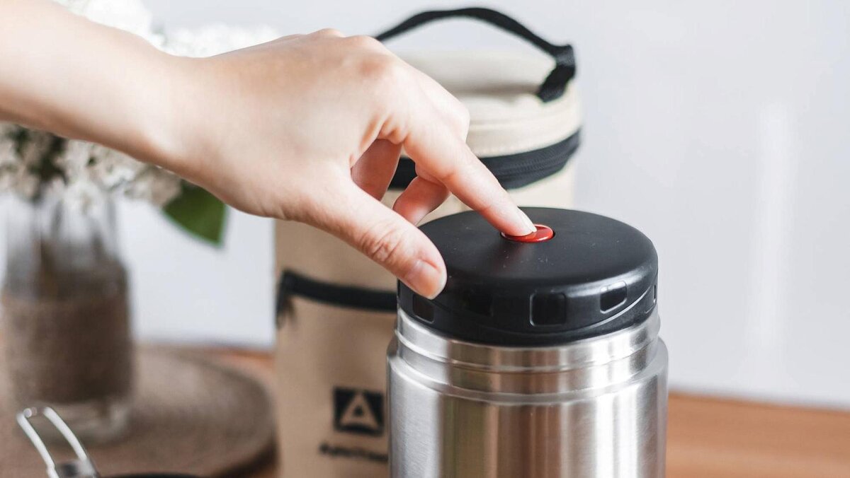 На термосах для еды часто есть специальная кнопка для стравливания воздуха - когда наполните термос, перед тем, как закрыть термос, нажмите ее. Если кнопки нет, просто откройте термос несколько раз.