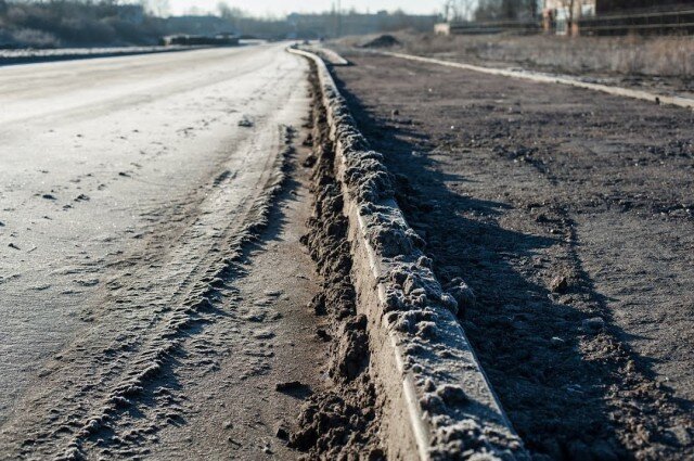 Велодорожка на дороге. Велодорожки у дорог. Разрушение склонов при строительстве дорог чрезмерна. Фонари на трассе в Калининграде.