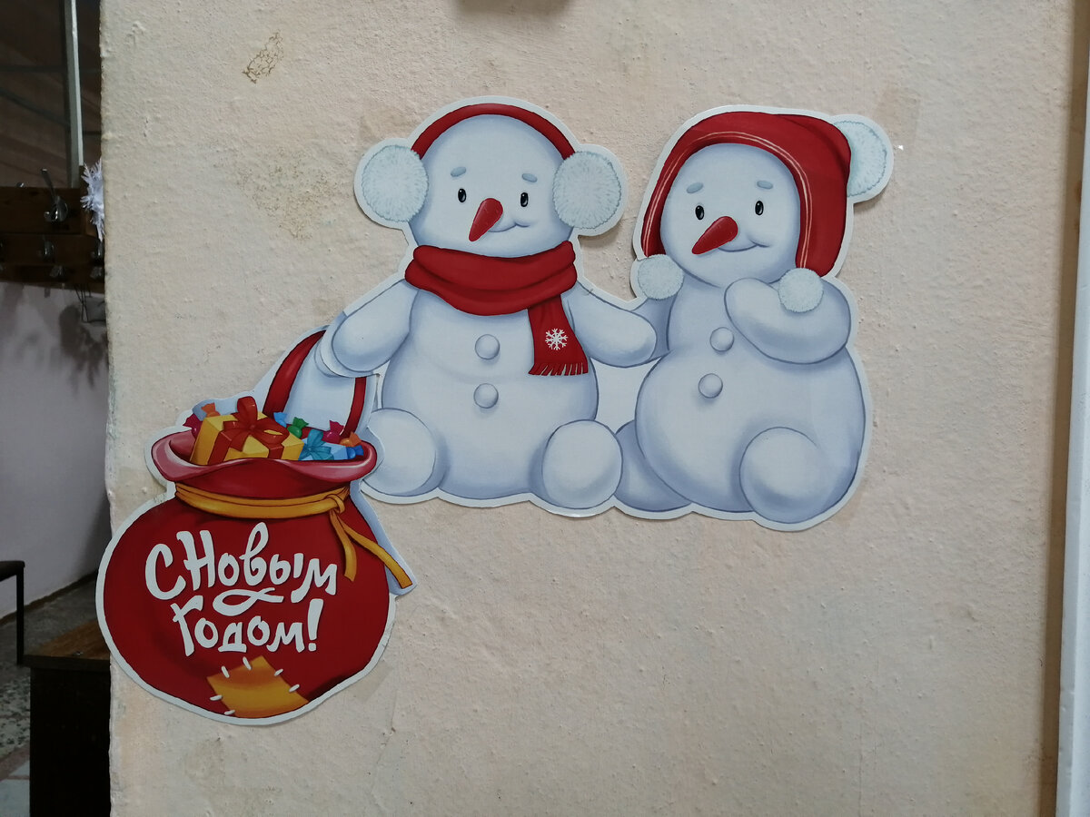 Пара милых снеговиков приглашают посетителей снять верхнюю одежду в гардеробе