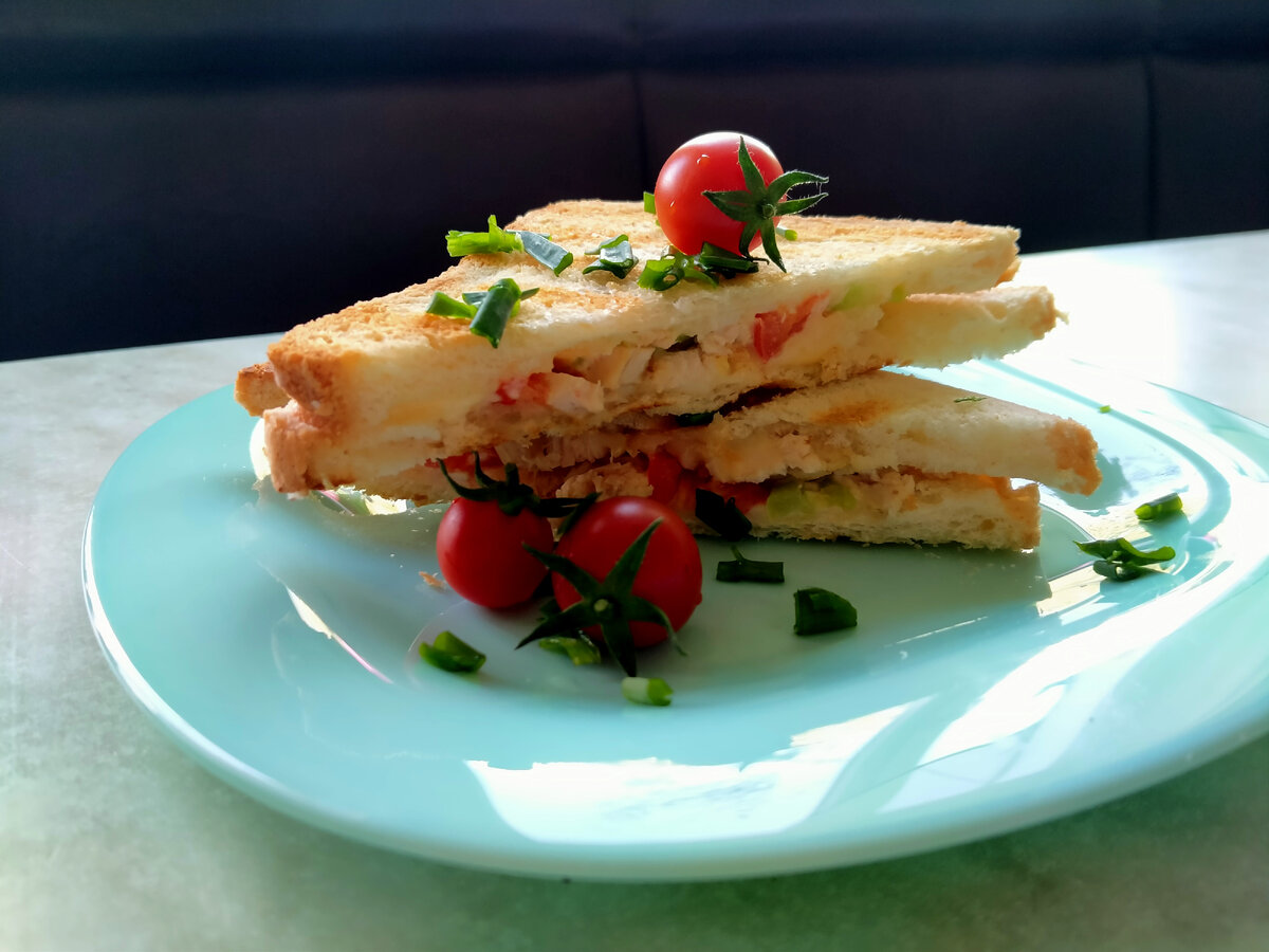 На фото сэндвич с печёным перцем, помидором, курицей в сухарях, сыром и зелёным луком
