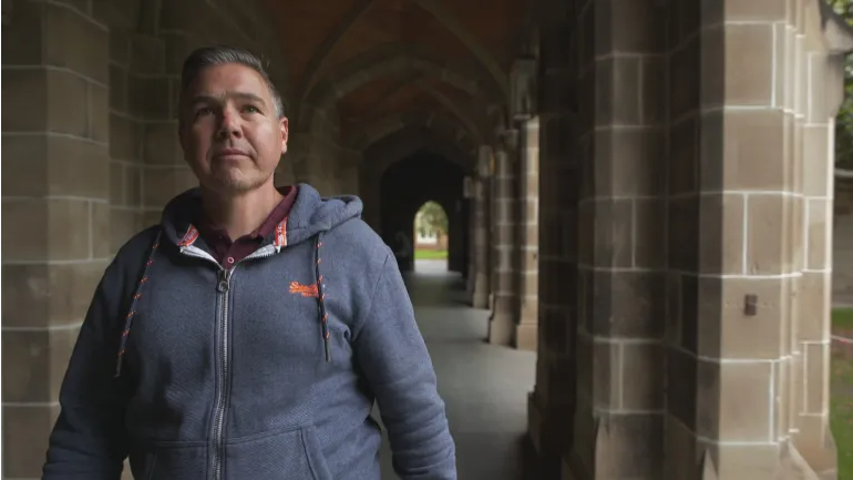 Доктор Эндрю Паск шагает по четырехугольнику Мельбурнского университета