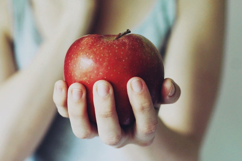 Протягивает яблоко. Рука протягивает яблоко. Яблоко в руке фото. Рука держит яблоко. Red apple with hand.