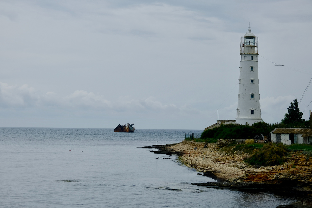 Маяк был построен еще в 19 веке. А сухогруз (слева) "Ибрагим-Яким" в декабре 2010 года сорвался с якорной стоянки и сел на мель. Следовал в Турцию.