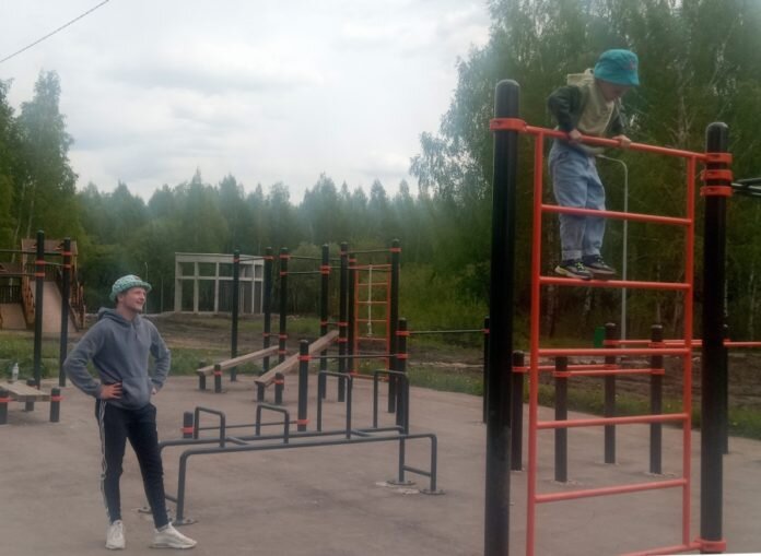 На уличных тренажерах в парке занимаются все