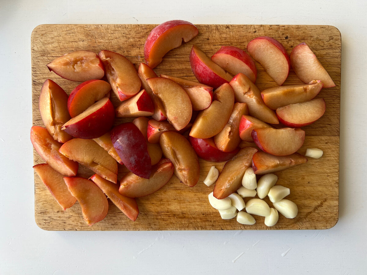 Сливу моем и нарезаем на четверти, косточки убираем. Чеснок рубим на 3-4 части