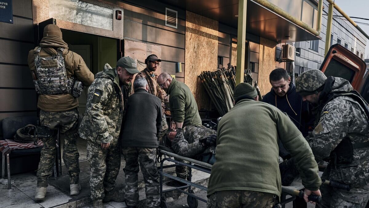    Военнослужащие ВСУ везут раненого солдата в Бахмуте© AP Photo / Libkos