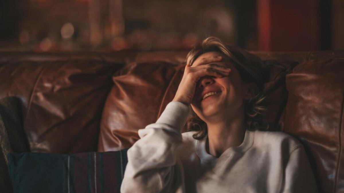    Женщина смеется, закрыв рукой глаза:Freepik