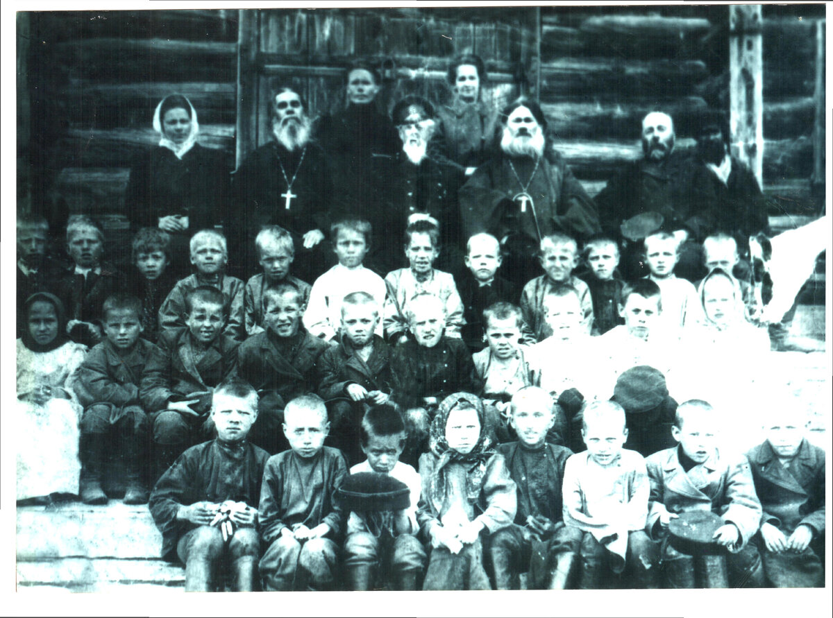  Ембское 1-е Земское училище, (открыто в 1879 году), д. Поповка. Фото 80-90-х годов XIX века. Надпись на обороте фотографии: " Слева на право пятая с краю учитель Ембского Земского училища Попова Юлия Николаевна, справа налево второй с краю капиталист Алаев Константин Иванович. Далее законоучитель школы священник Образцов, рядом инспектор училищ и группа учащихся... 