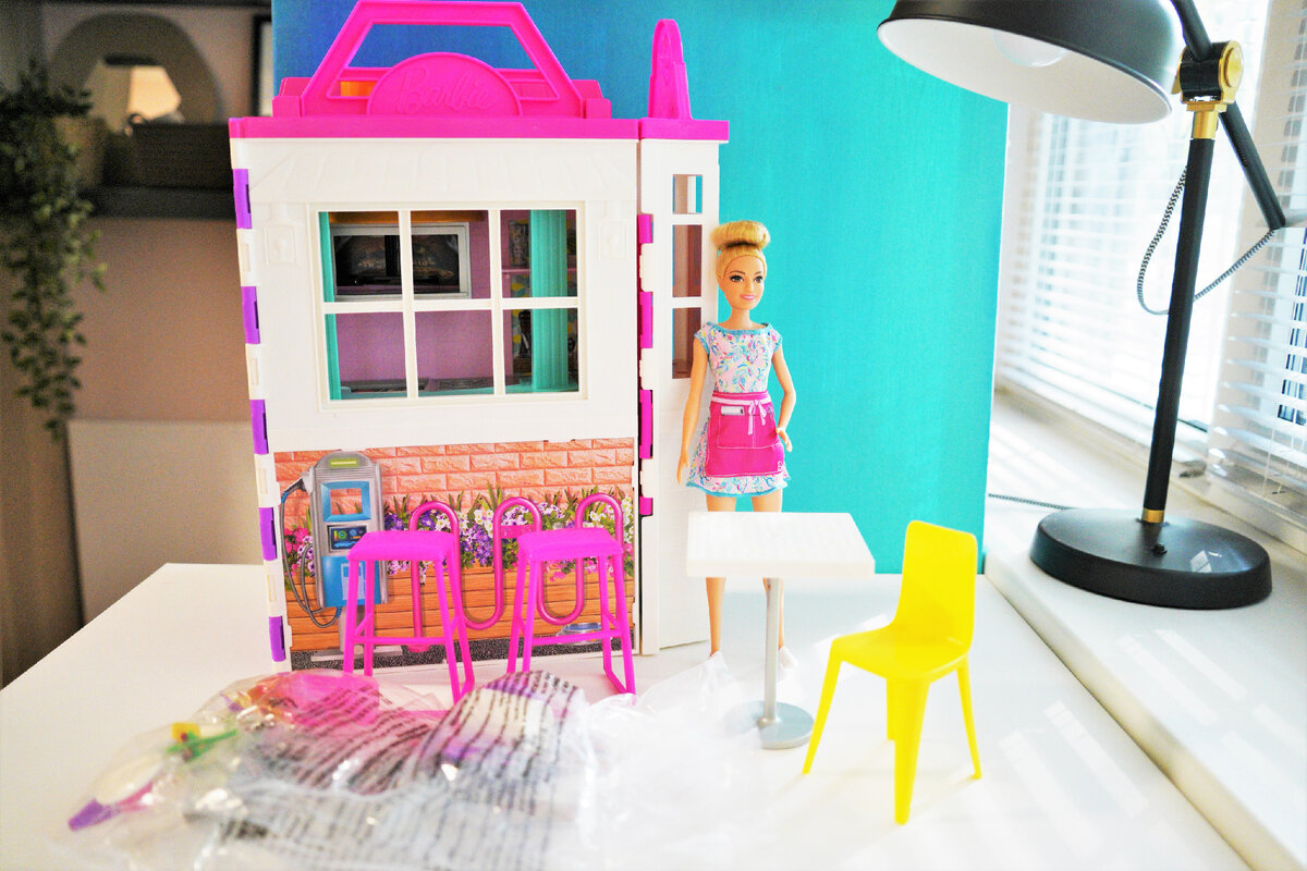 То что мы видим сразу после распаковки. В наборе: домик, аксессуары и кукла в одежде и с поварским колпаком (который держится за счет штырька с внутренней стороны и прически куклы, в которую этот штырек вставляется, забавная система). Листайте дальше.