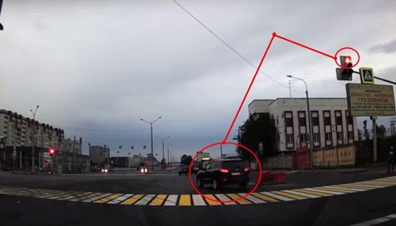 Красный светофор горит уже 2 секунды, но запоздалый нарушитель-торопыга пытается проехать перекресток.