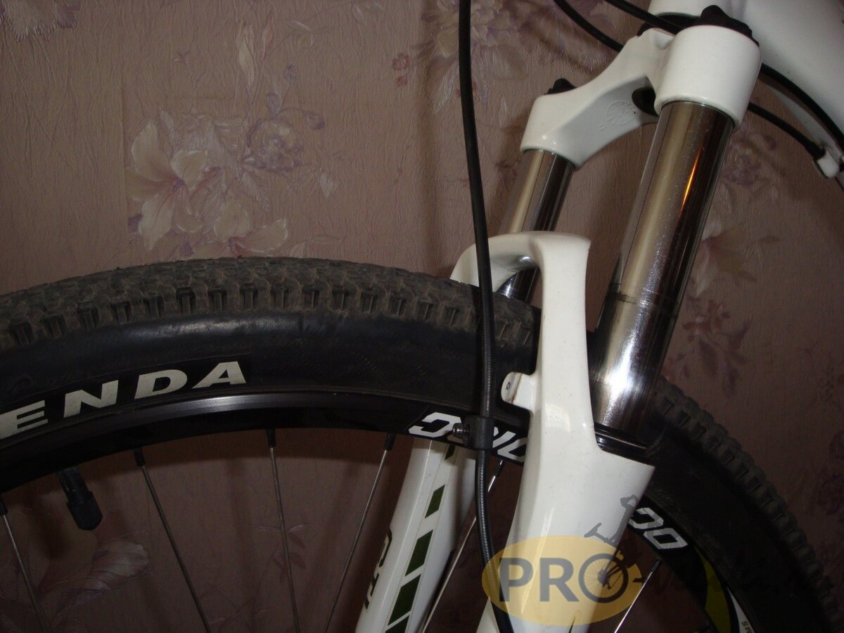 Первым делом выполняем подготовительные работы, а именно откручиваем все, что крепиться к вилке. В нашем случае это калипер тормозной системы, а также гидролиния передних дисковых тормозов, которая крепится зажимом к штанам вилки. Если у вас установлены тормоза типа V-brake, то демонтируем их. Это также касается датчика скорости, идущего от велокомпьютера, переднего крыла и т.д.