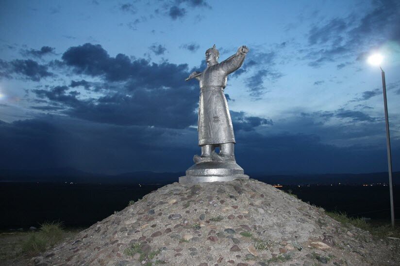 Адрес: автотрасса Кызыл-Эрзин, 9 км. Остановка транспорта «Аэропорт».Главным символом Кызыла и всей республики Тыва считается монумент Кадарчы, воздвигнутый на вершине небольшого холма напротив городского аэропорта. Скульптурное воплощение пастуха, облаченного в национальные одежды и крепко стоящего на родной земле, как нельзя лучше олицетворяет душу вольнолюбивого тывинского народа. Фигура Кадарчы излучает уверенность в своих силах. Его руки опираются на посох, закинутый за плечи, а взгляд устремлен вдаль, где на бескрайних степных просторах пасутся огромные стада овец. У подножия памятника размещено около сотни белых камней, символизирующих отару.