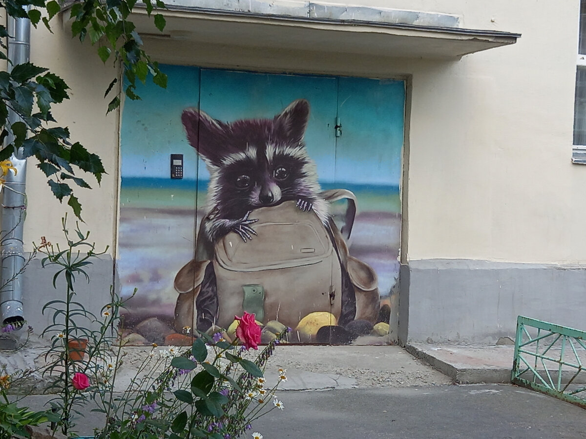 Енот и Бурундук на дверях подъезда радуют жителей дома Попова 9. Прохожих они тоже радовали, так что пришлось отгородиться забором и поставить будку с вахтером, чтоб не шастали тут и не портили искусство