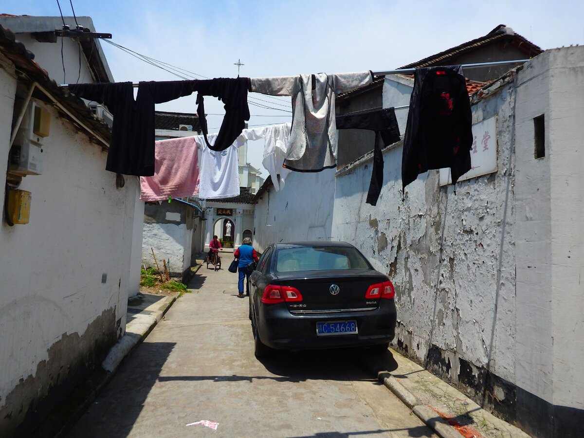  Это не тот Шанхай, который представляют себе туристы, глядя на высокие небоскребы на картинках, но это настоящий Шанхай. 
А настоящий Шанхай это:
1. Много развешанного белья. Китайцы привыкли сушить одежду на улице, т.к. дома сыро, часто грязно и не хватает места. Что касается уличной пыли, то ей покрывается одежда только с одной стороны. А этого достаточно.

