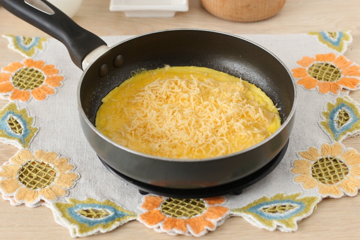 Посыпанный сверху сыр в момент, когда яичница немного схватилась.