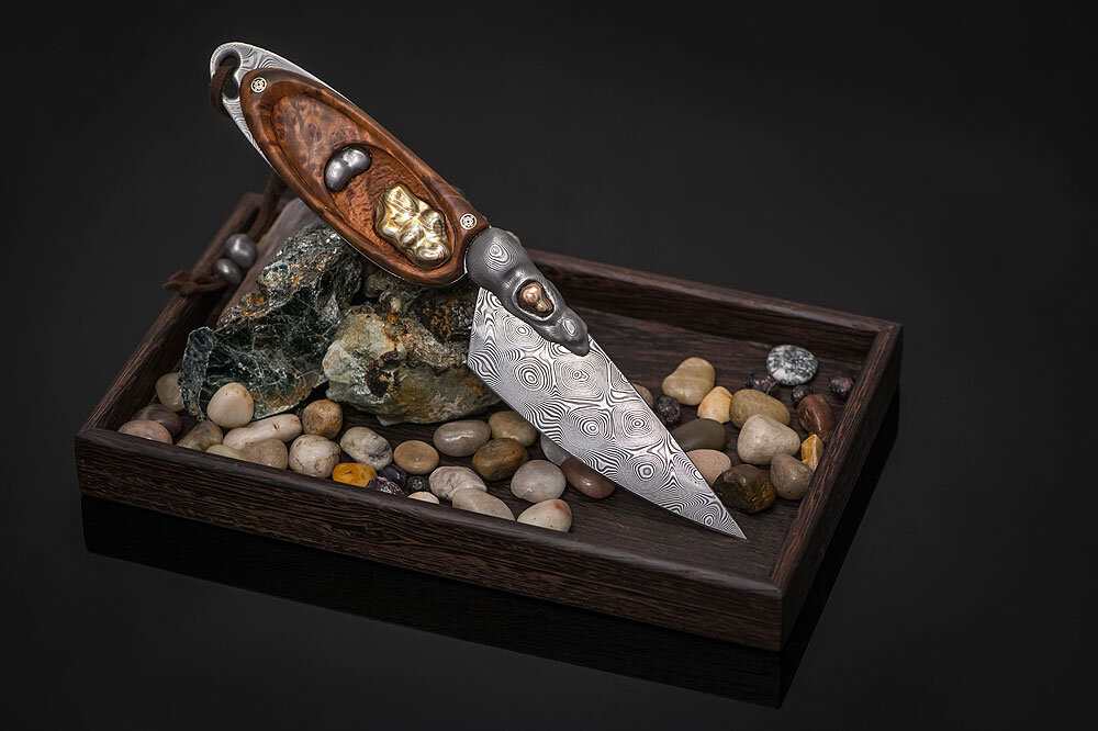 Авторская композиция «Сад камней» (АиР, Златоуст). Нож изготовлен из премиального дамаска Zladinox (Герасимов Владимир) с применением мокуме гане, камней «лабрадор», «пейзажный агат», «тигровый глаз», а также стабилизированного капа и венге. Стоимость композиции 172 480 рублей.