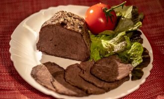 Нарезать тонкими пластинами поперек волокон и подать к столу.