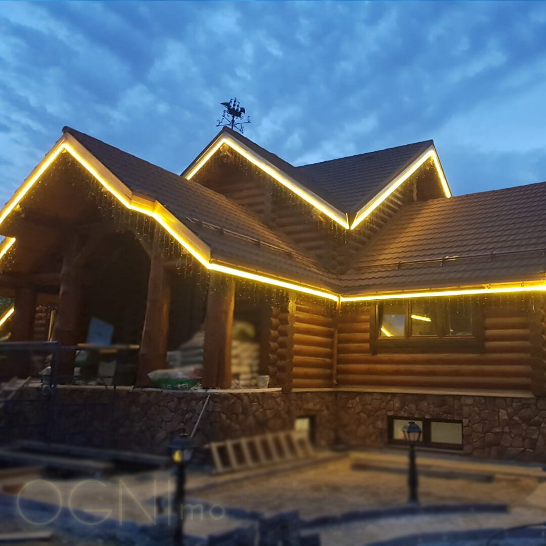 Прекрасный вариант для деревянного коттеджа или любого другого, и чем интереснее с точки зрения архитектуры будет крыша, тем ярче результат. Контурная подсветка может быть сделана с помощью неоновых трубок, светодиодных лент или дюралайта. Это разное по характеристикам и стоимости оборудование, но эффект получается похожим. 
