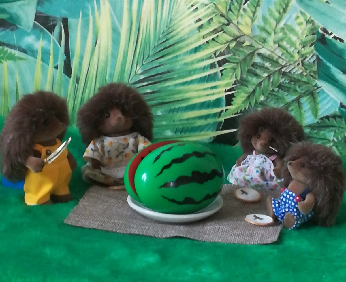 Семья ежей устроила пикник на поляне чтобы поесть арбуз со своего огорода. Арбуз вырос таким огромным, что папе ежу пришлось взять самый большой нож, чтобы его порезать. 