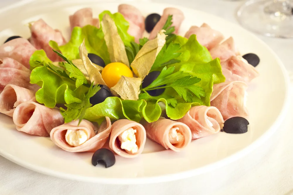 Рулетики из ветчины  – прекрасная закуска с многовариантным исполнением, они могут быть с совершенно разными начинками, а так же могут быть как холодными, так и горячими. Мы приготовим несколько вариантов рулетиков – 2 варианта холодных рулетиков и один вариант – горячий.