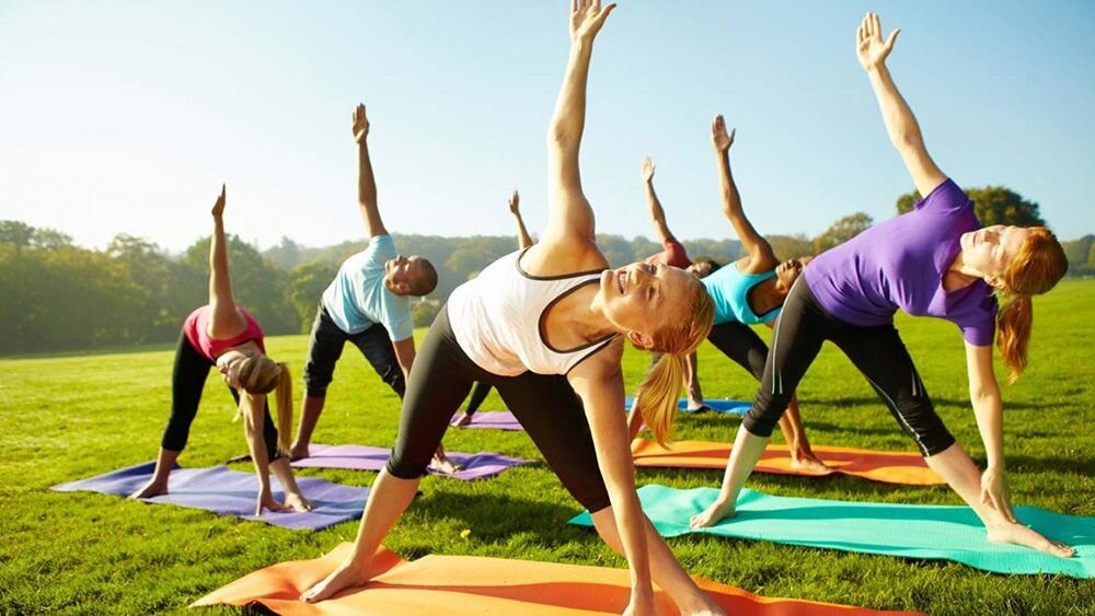 спортивные люди. суставная гимнастика. занятия на свежем воздухе. занятия спортом на свежем воздухе. физические упражднени.