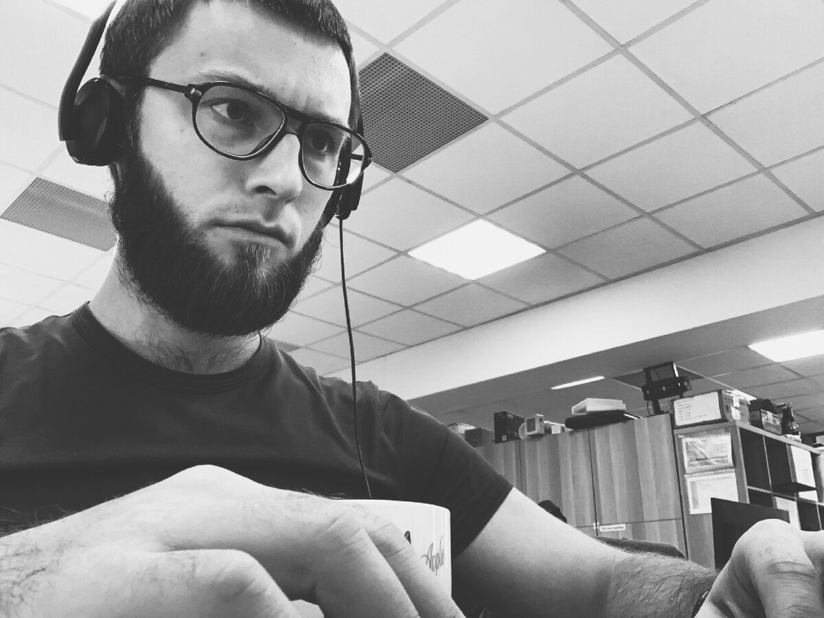 На фото: Николаев эР с серьезным видом пялится в рабочий ноутбук Lenovo.