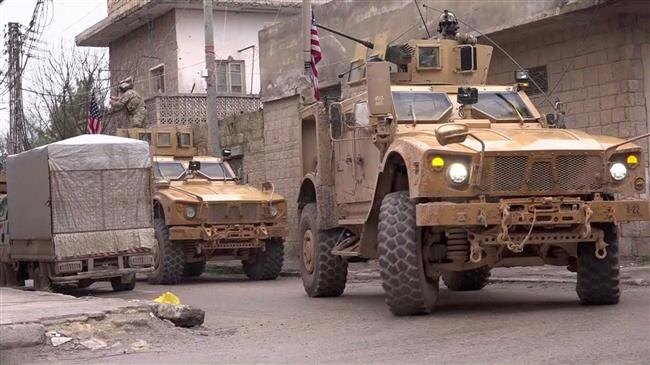 На снимке, сделанном с видео, выложенного AFPTV 16 января 2019 года, бронетехника США на месте теракта в Манбидже.