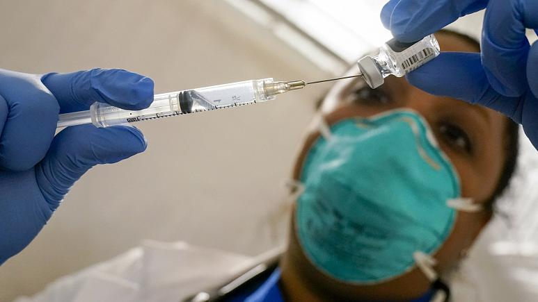 Медицинский работник извлекает вакцину Pfizer COVID-19 из флакона на месте вакцинации в Восточном Гарлеме, Нью - Йорк, 15 января 2021 г.