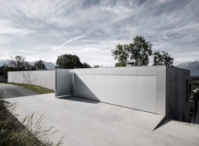 Фасад дома в виде стены с металлическими воротами 