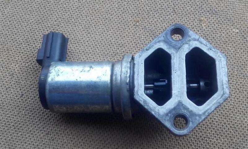 Типичный регулятор холостого хода. Слева цилиндр электромотора, а в прорезях-каналах виден его вал, на котором находится вращающаяся заслонка. (фото: sobut.ru)