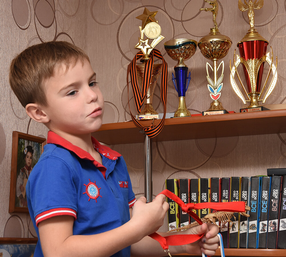 Егор с гордостью показывает свои спортивные награды