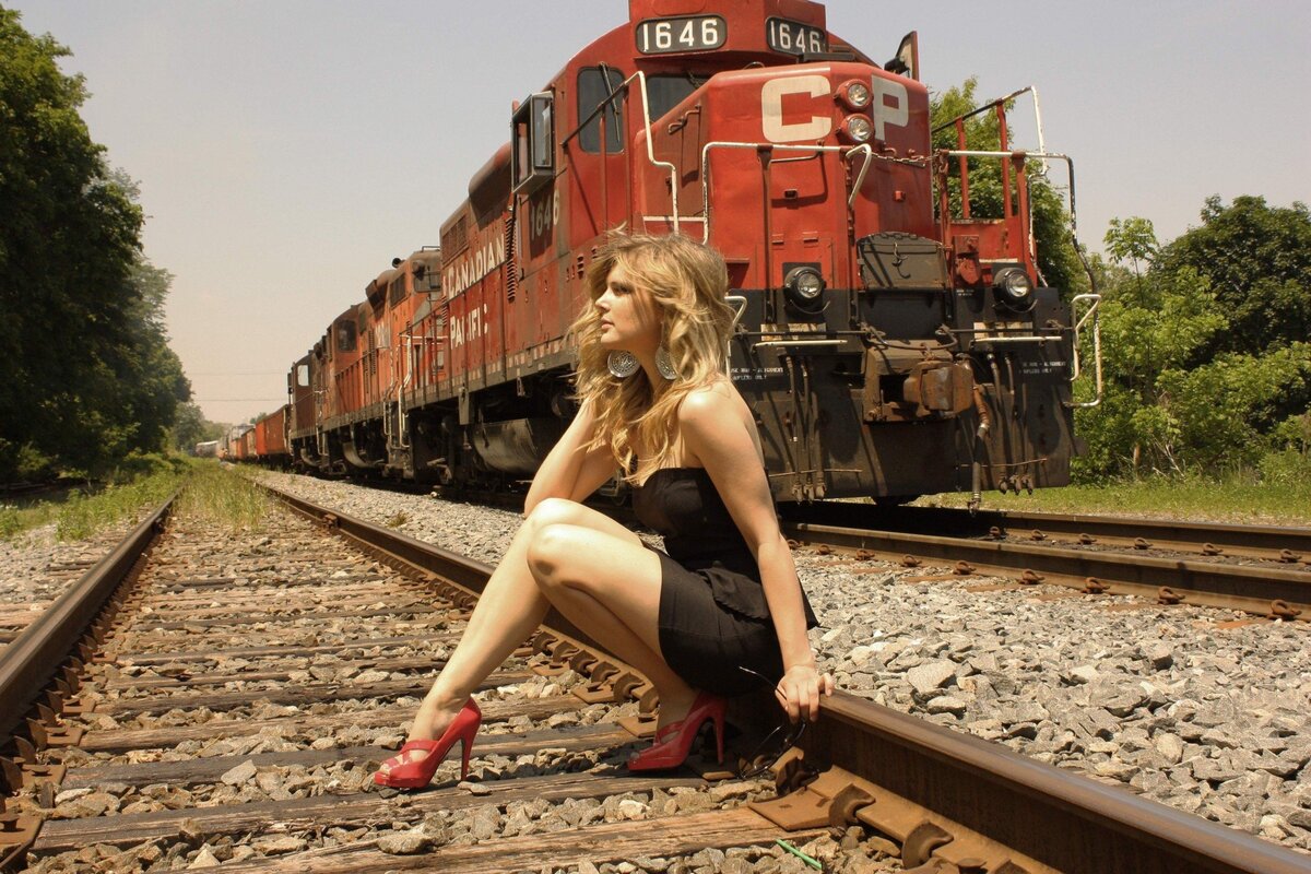 красивая девушка в плаще на фоне поезда Stock-Foto | Adobe Stock