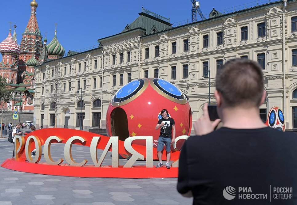 © РИА Новости/ Евгений БиятовПерейти в фотобанкМолодые люди фотографируются рядом с символикой, посвященной предстоящему чемпионату мира по футболу 2018 года в Москве
