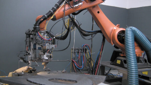 Рис. 1. В ходе изготовления используется оборудованный лазерной головкой робот, а сам процесс основан на послойном нанесении лазером уже предварительно разогретой проволоки. Изображение предоставлено Midwest Engineered Systems Inc./Robotic Industries Association (RIA)