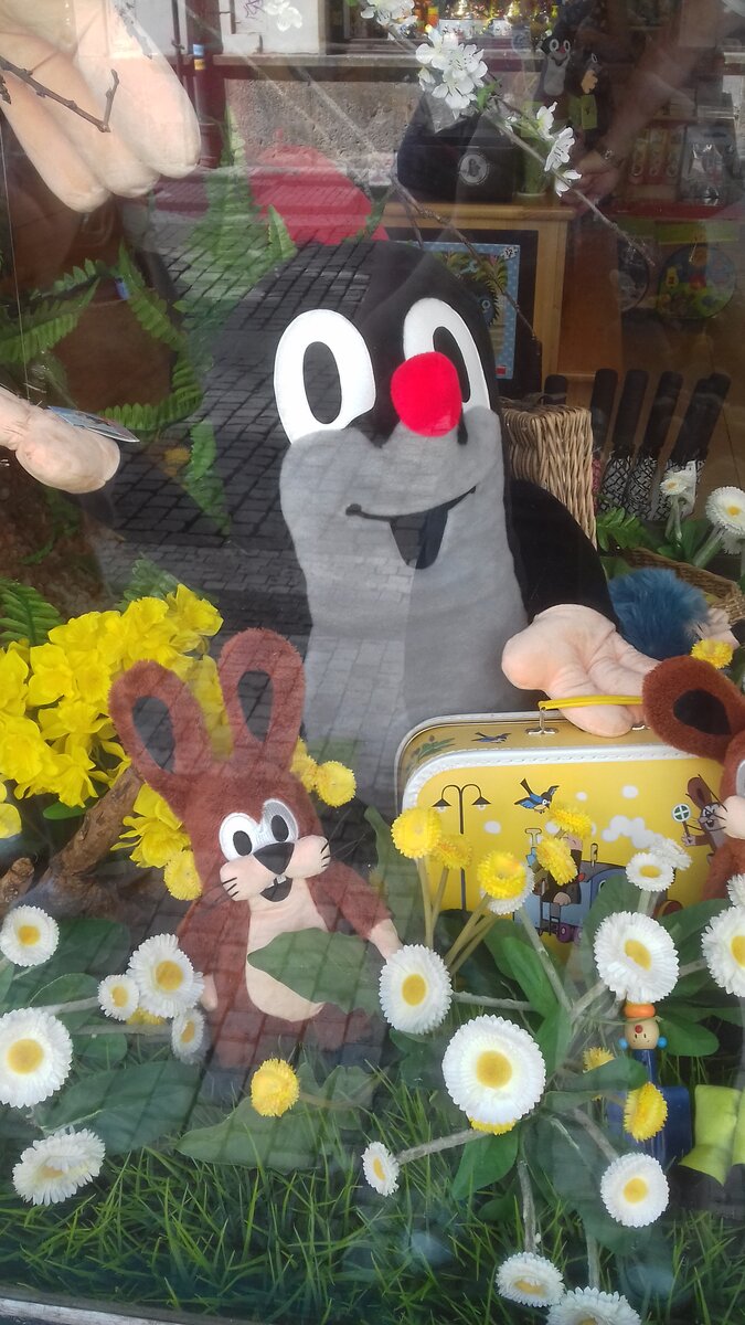 Огромный кротик в витрине магазина машет всем туристам.