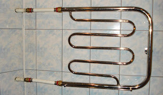 Теперь переходим к работе полотенцесушителя. Когда стояк горячей воды находится в ванной или в туалете сразу за стеной ванны проблем обычно не возникает (трудно что-либо испортить). Хуже, когда этот стояк находится дальше – у противоположной стены туалета, в этом случае необходимо прокладывать две подводящие трубы от стояка горячей воды в полотенцесушителю длиной 1,2-1,7 метра (через всю стену туалета) – а это уже создает сопротивление движению воды из стояка в полотенцесушитель и обратно и, кроме того, при неаккуратной прокладке подводящих труб может образоваться воздушный пузырь (воздушная пробка), мешающий движению воды.    Поэтому, если после монтажа полотенцесушителя обнаружилось, что он плохо греет, первое что надо проверить – это расположение подводящих труб: они должны быть ровными и  место подключения труб к стояку должно быть выше места подключения к полотенцесушителю на 4-7 мм, можно и больше, например 2 см или 3 см, но тогда явно будет видно, что трубы проложены «косо», что не совсем красиво. Как проверить уклон? Если нет уровня, можно замерить расстояния от трубы до пола.