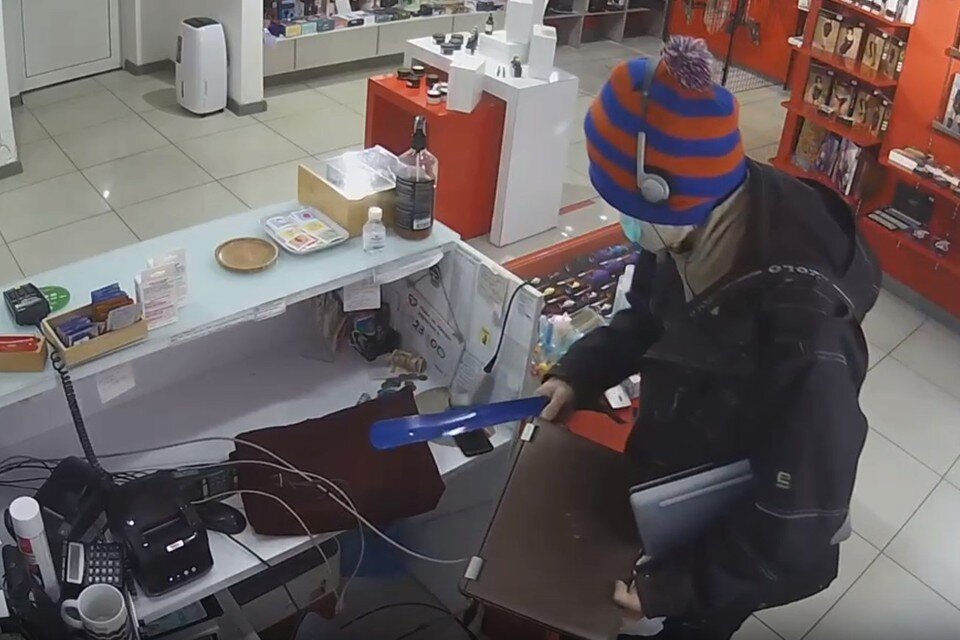    Когда продавщица сбежала, нападающий переключился на ноутбуки. Фото: скрин видео