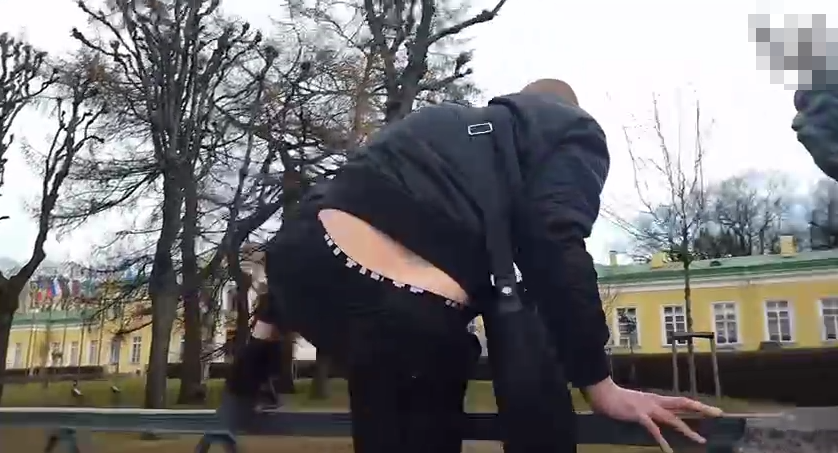 Кадр с видео, где активист перепрыгивает забор и попадает на территорию у Таврического.
