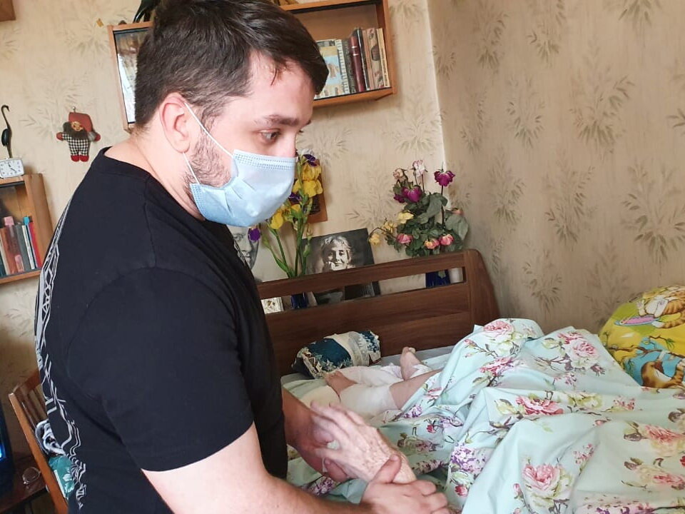 Фельдшер Александр осматривает подопечную фонда, у которой несколько пролежней на ногах и на спине