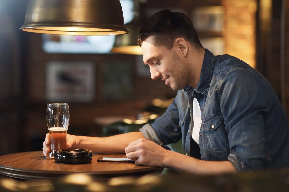 Гость бара «Правда или действие» пользуется их мобильным приложением.