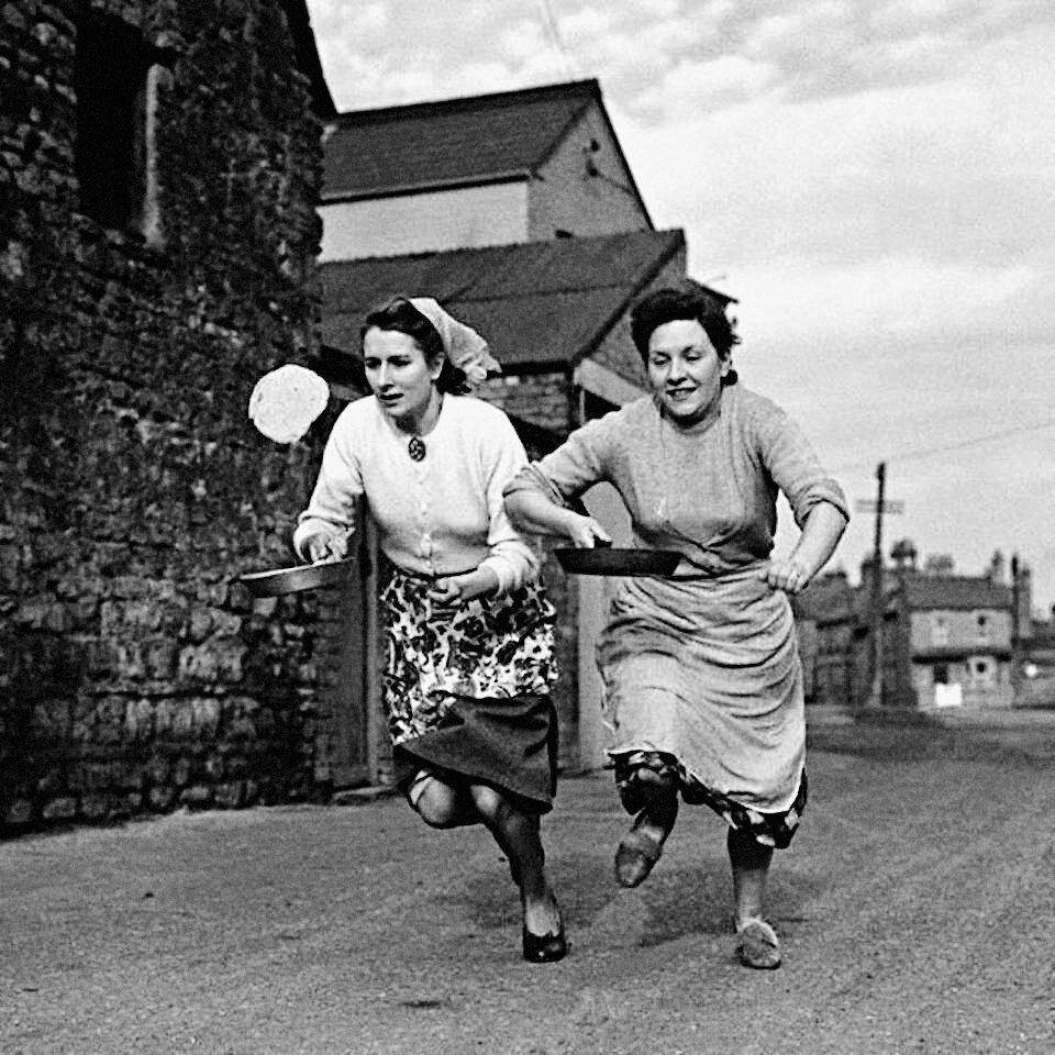 Женщины тренируются перед участием в ежегодной гонке с блинами. Великобритания, 1950 год.