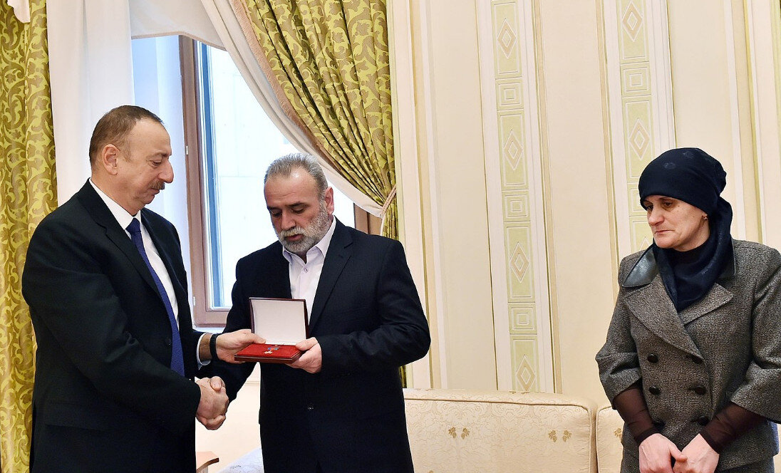 На фото: Президент Азербайджана Ильхам Алиев передаёт отцу Чингиза Курбанова медаль «Золотая Звезда» Национального героя Азербайджана.