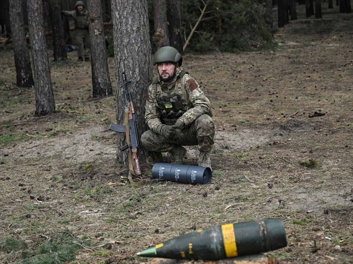 Украинский военнослужащий перед снарядом от 155-мм гаубицы ТРФ-1© AFP 2023 / ARIS MESSINIS