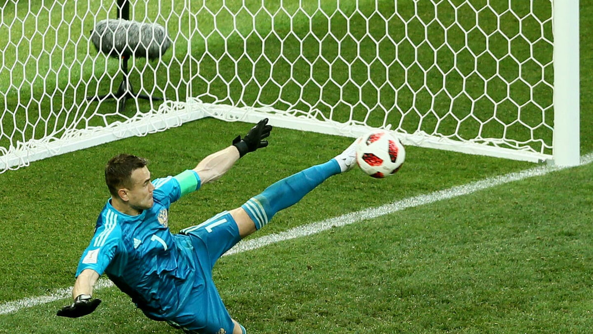 В акробатическом прыжке Акинфеев отбивает 11-метровый удар испанцев. Фото fifa.com