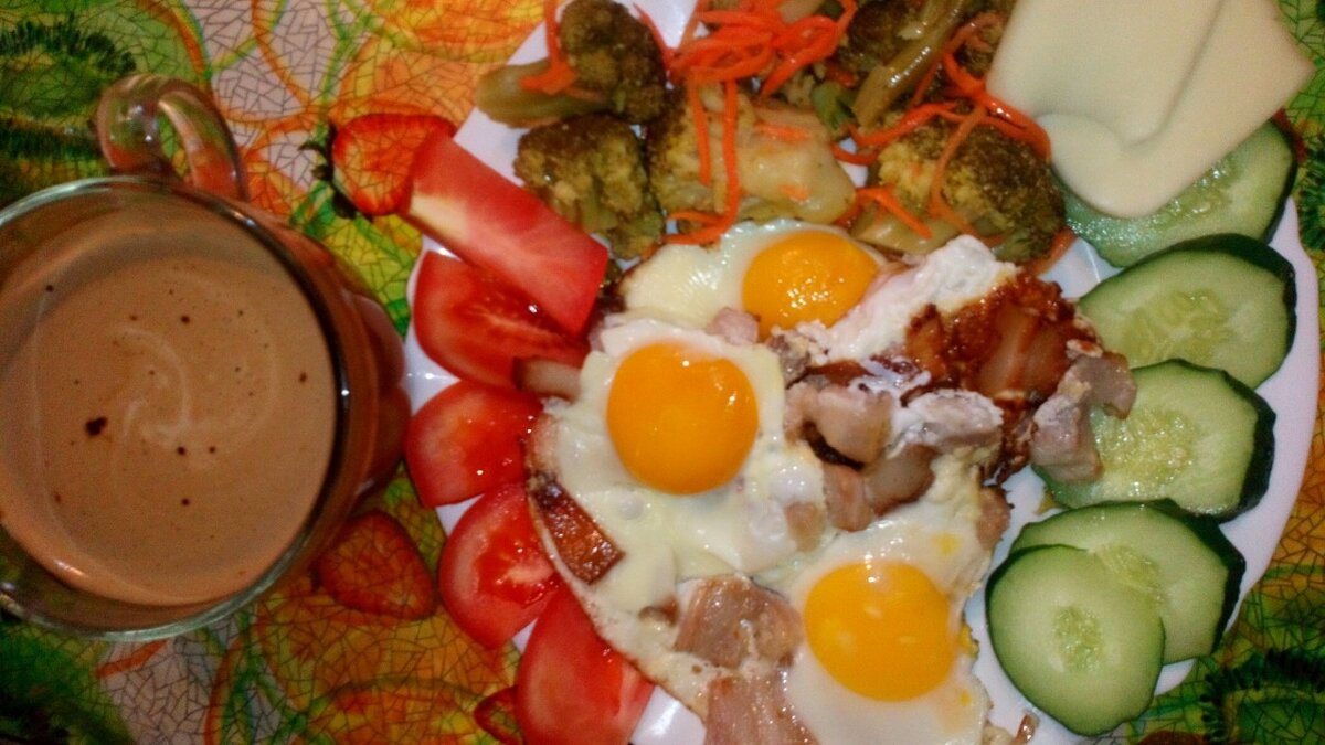 Глазунья, жареная грудинка, сыр, маринованная брокколи, огурец, помидор, кофе с молоком.