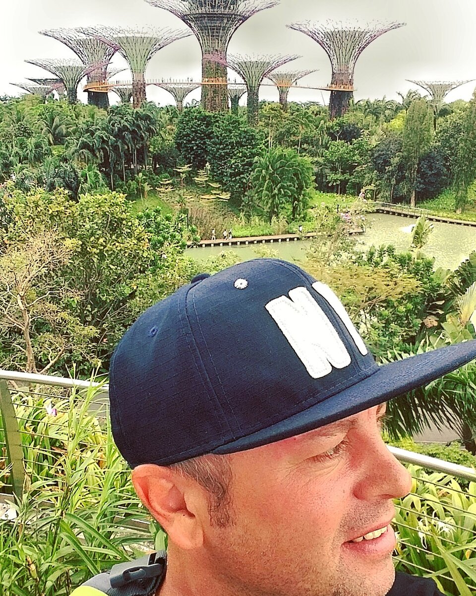 Сзади Gardens By The Bay и я в новой кепке, по челюсть с правой стороны лица, делаю селфи правой рукой, но смотрю влево:)