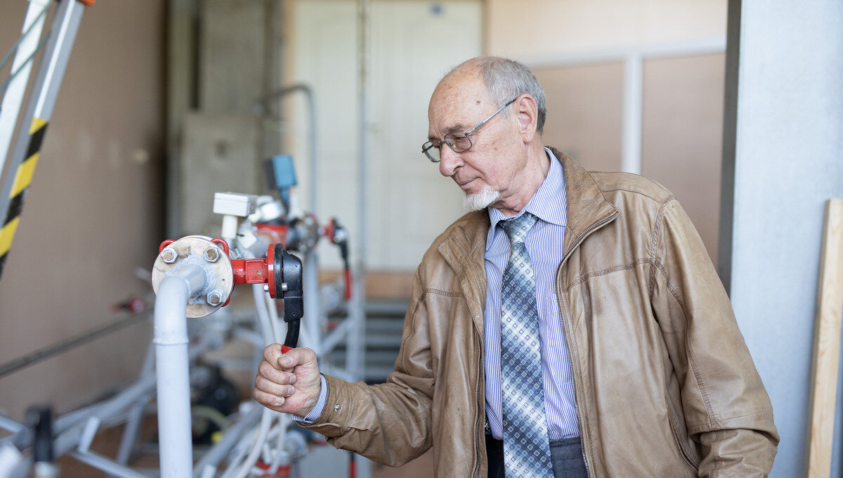 Сергей Щеклеин у стенда, в котором циркулируют газы, жидкости при разных давлениях. Фото: Илья Сафаров, медиацентр УрФУ.